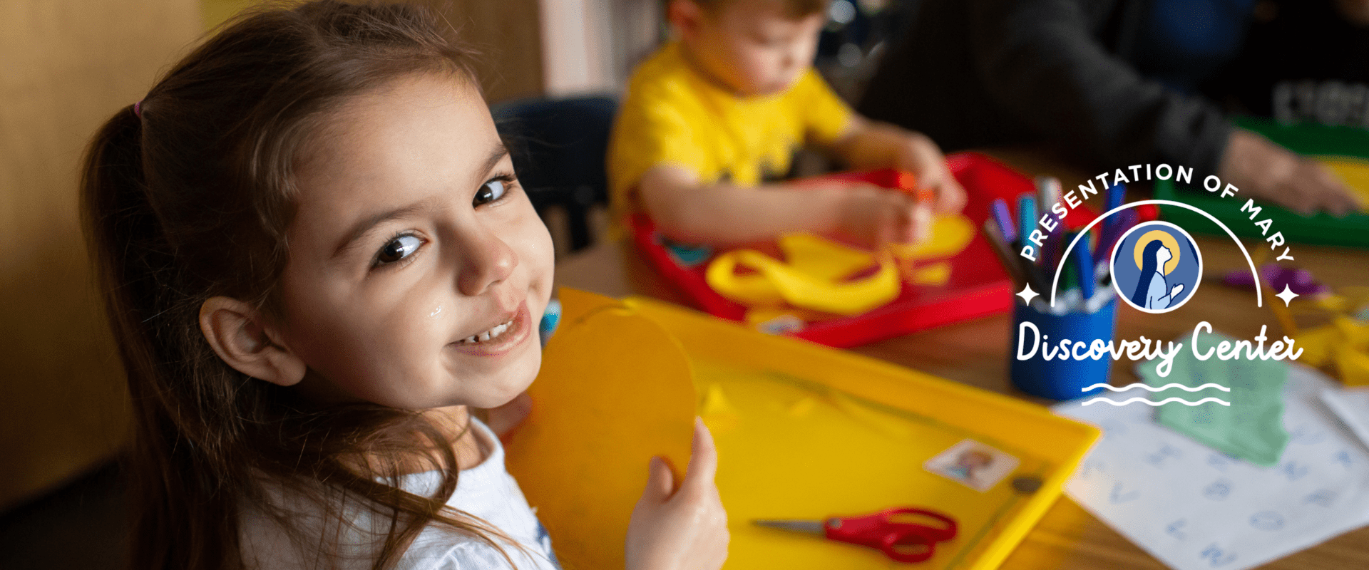 preschool girl smiling while coloring