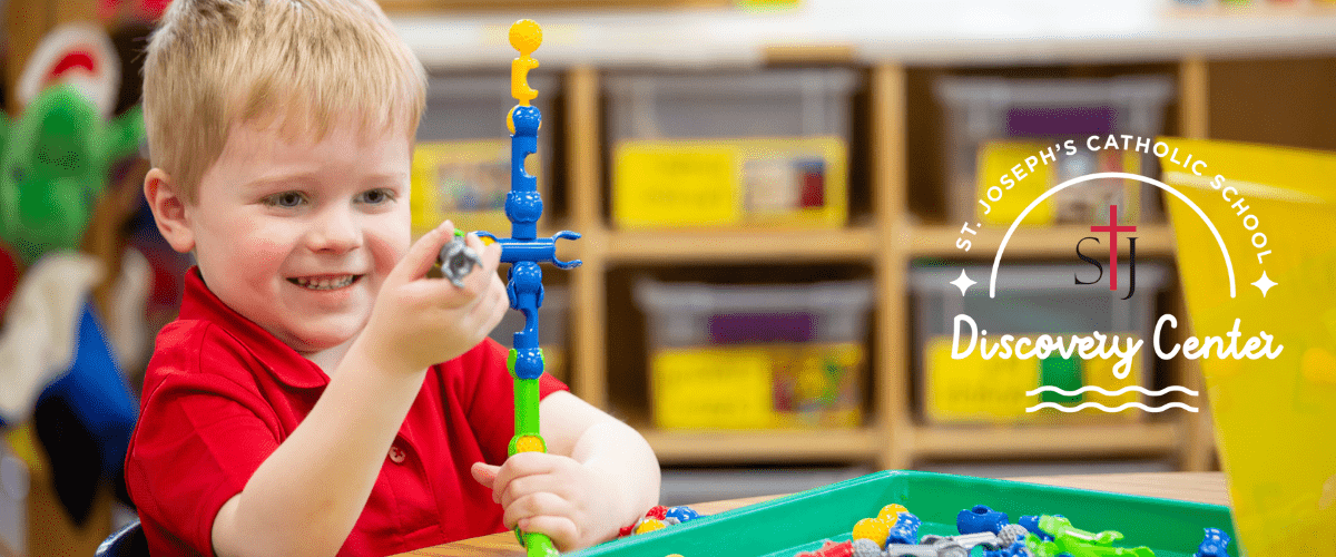 male preschool student using colorful building blocks